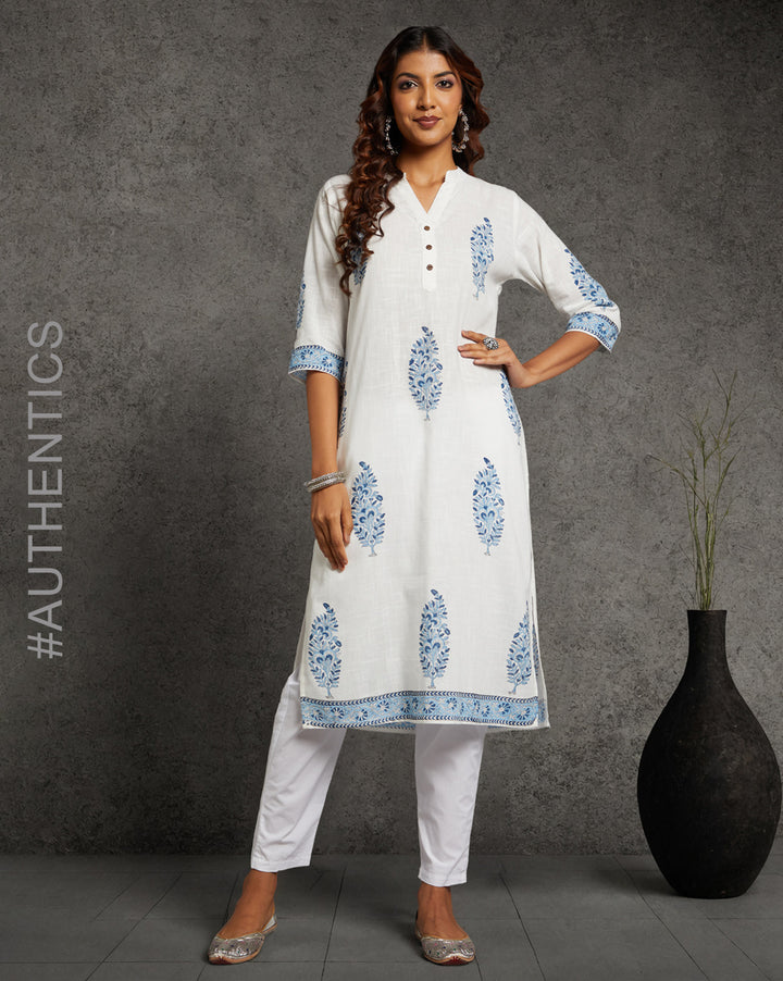 Stylish White linen Straight Kurta with Chinese Collar and V-Neck, paired with white pant and jutti, worn by a woman standing next to a flowerpot.