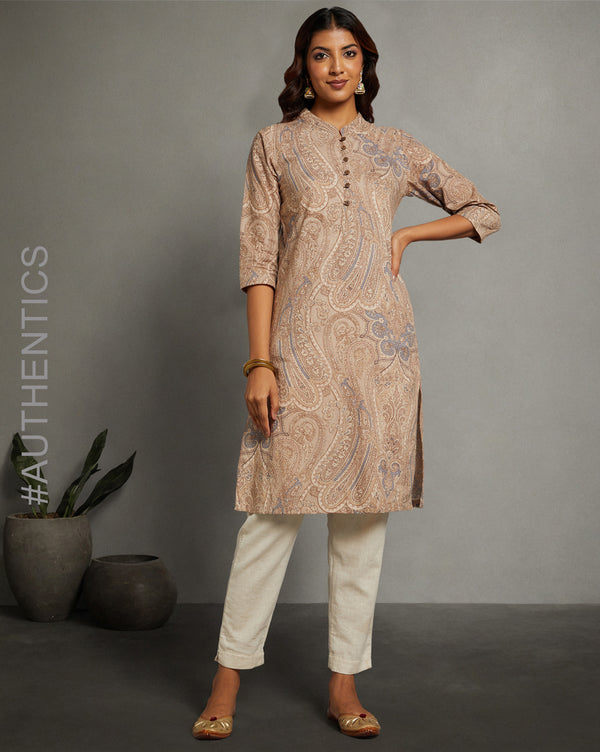 Stylish Brown Floral Hand Block Cotton V-Neck Kurti, paired with white pant and jutti, worn by a woman standing next to flowerpot.