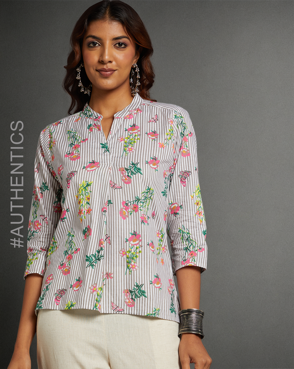 Stylish Grey Floral print V neck Short Kurta, paired with white pant and jutti, worn by a woman standing.