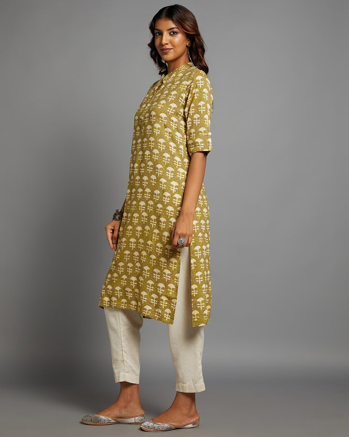 
Side profile of a Printed green Cotton Kurti paired with white pant and jutti, showcasing the kurti's length and the smooth drape over the body