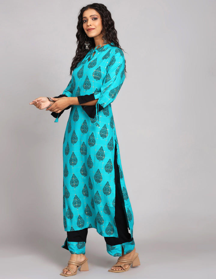 
Side profile of a Printed Blue Color Cotton Knee Length Kurta with three-fourth sleeves paired with brown sandals, showcasing the kurti's length and the smooth drape over the body