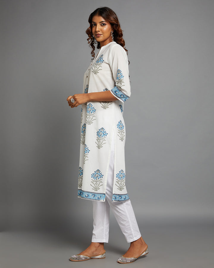 Side profile of a woman wearing White Cotton Straight Kurta with Chinese Collar and V-Neck with three-quarter sleeve paired with white pant and jutti, showcasing the kurti's length and the smooth drape over the body