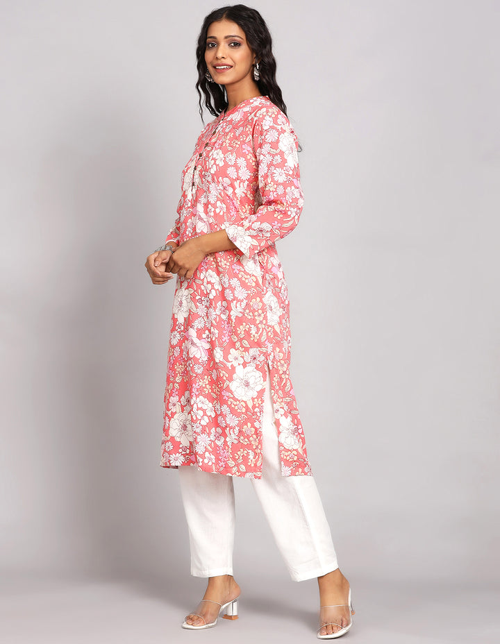 Side profile of a Peach Pink Long Kurti with Collar Neck Line, and three fourth sleeves with white pant and transparent sandals, showcasing the kurti's length and the smooth drape over the body