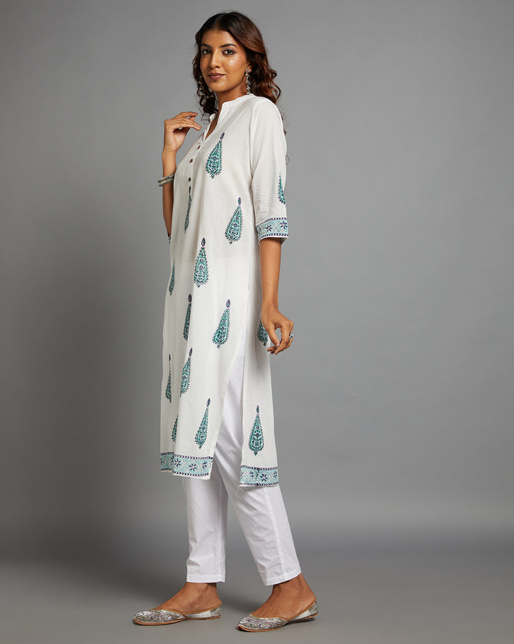 Side profile of a woman wearing White Cotton Straight Kurta with Chinese Collar and V-Neck with three-quarter sleeve paired with white pant and jutti, showcasing the kurti's length and the smooth drape over the body