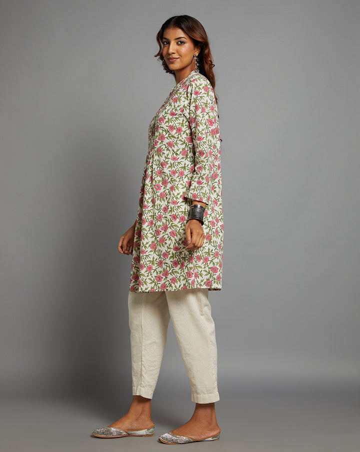 Side profile of a woman wearing Floral Print Cotton A-Line Kurta with Round Neck with three-quarter sleeve paired with off-white pant and jutti, showcasing the kurti's length and the smooth drape over the body