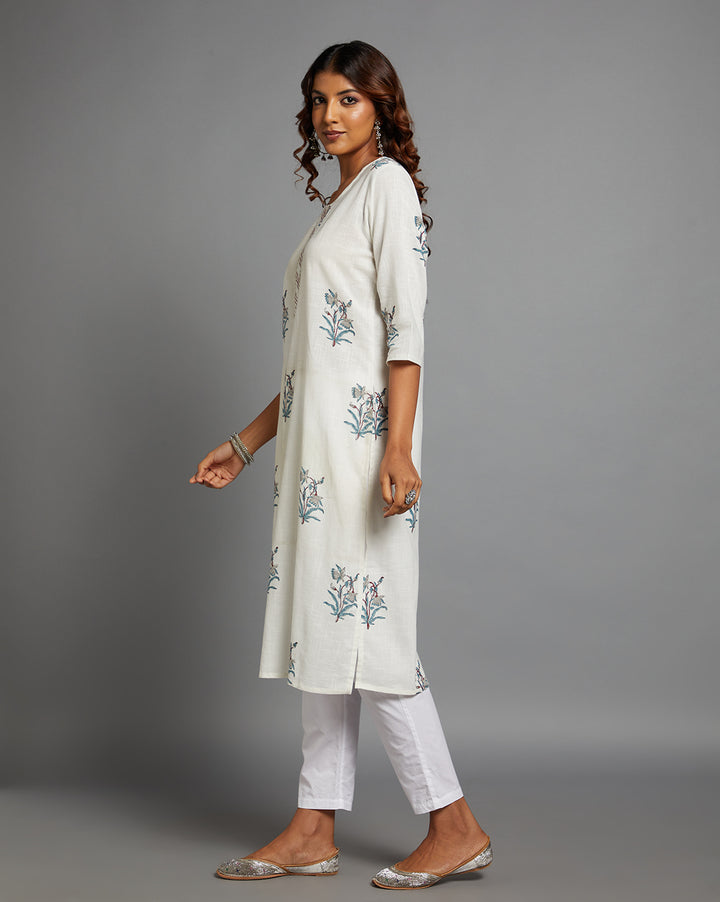 Side profile of a woman wearing White Cotton Straight Kurta with round Neck with three-quarter sleeve paired with white pant and jutti, showcasing the kurti's length and the smooth drape over the body