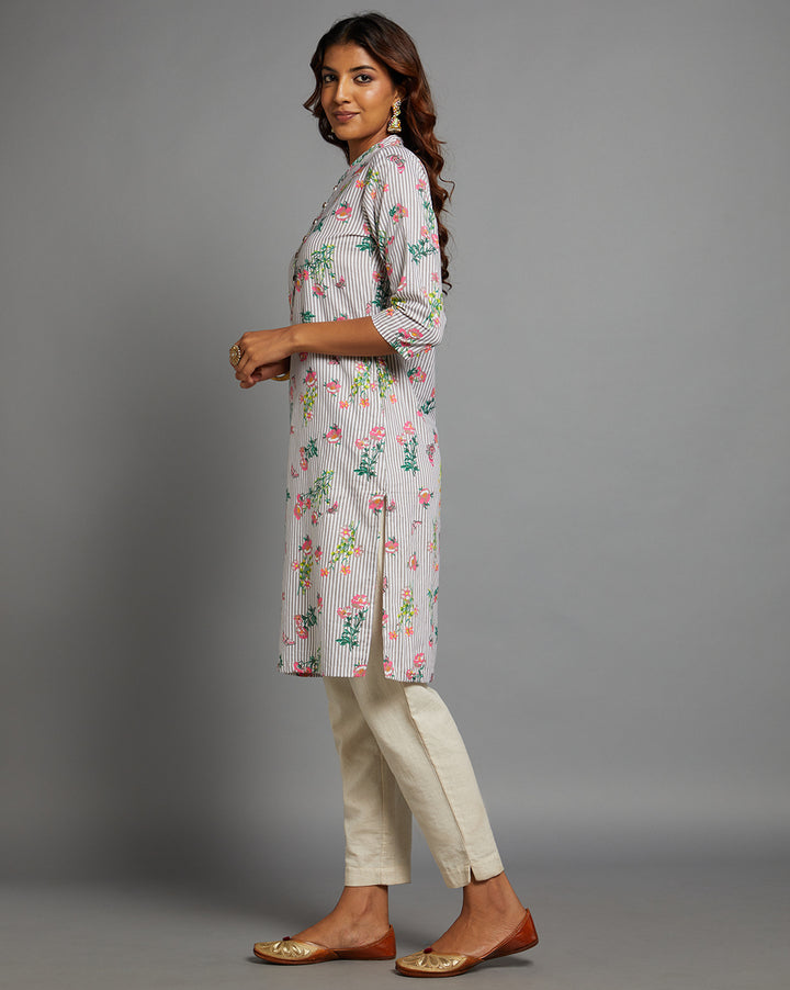 Side profile of a woman wearing a Grey Floral Hand Block Cotton V-Neck Kurta with three-quarter sleeve paired with off white pant and jutti, showcasing the kurti's length and the smooth drape over the body