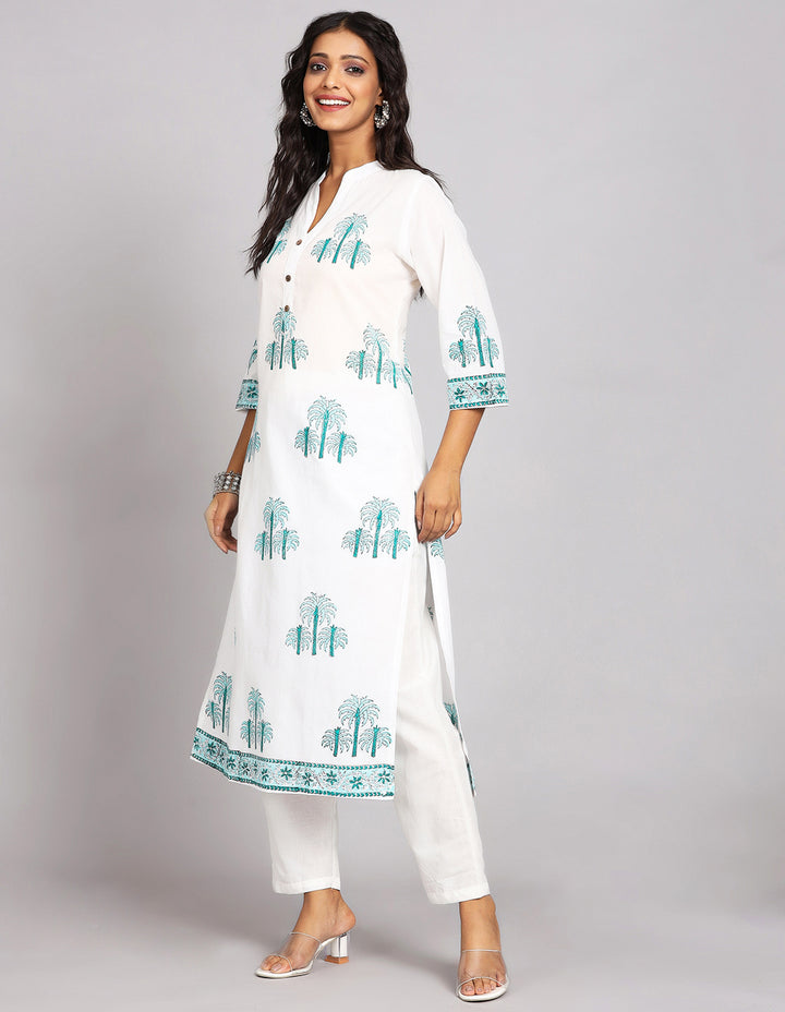 Side profile of a White Long Kurti With Hand Block Print, and three fourth sleeves with white pant and transparent sandals, showcasing the kurti's length and the smooth drape over the body