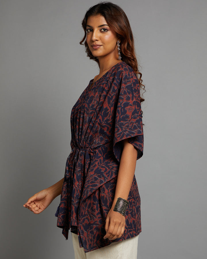 Side profile of a woman wearing a Dabu printed Navy and Maroon color cotton kaftan, paired with white pant and half sleeve, showcasing the kurti's length and the smooth drape over the body