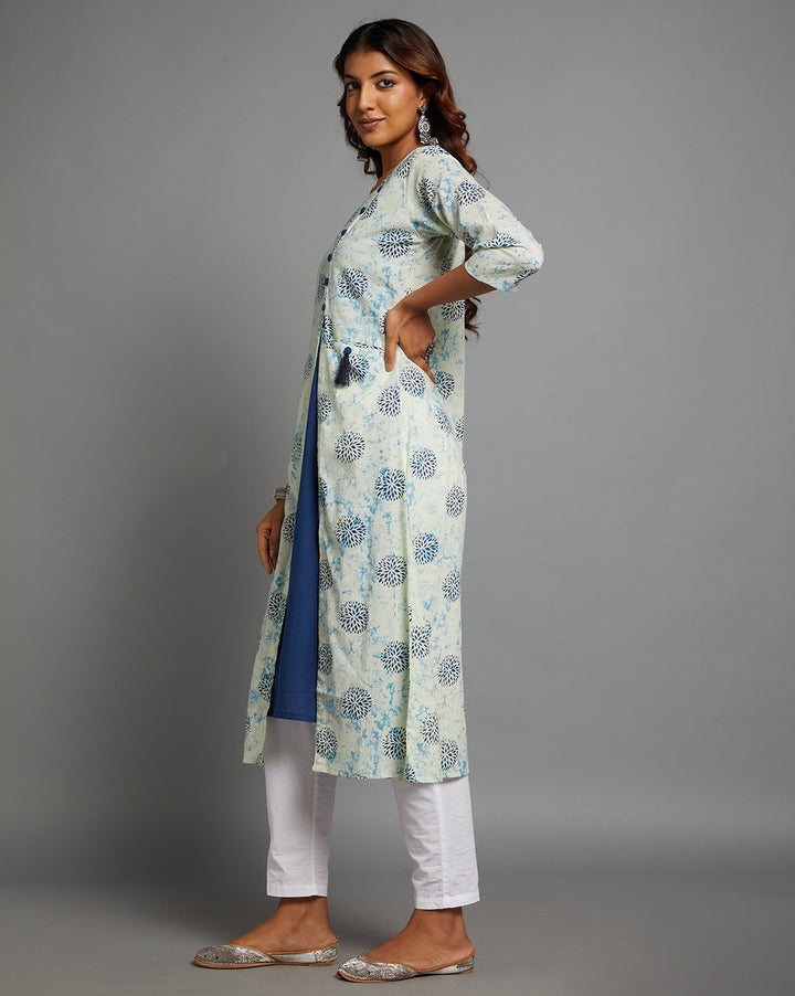 Side profile of a woman wearing White and blue Cotton A-line Kurti with roung neck with three-quarter sleeve paired with white pant and jutti, showcasing the kurti's length and the smooth drape over the body