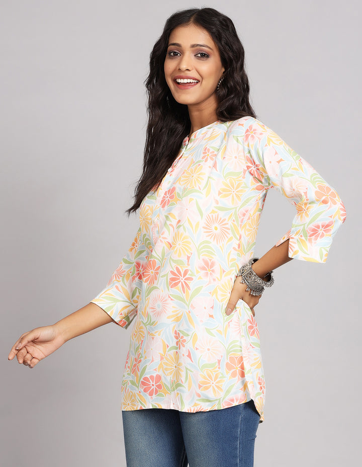 Side profile of a woman wearing a multicolored short kurti top with three-quarter sleeves and blue skinny jeans, showcasing the top’s length and the smooth drape over the body