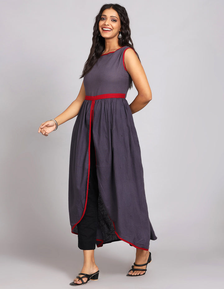 Side profile of a woman wearing a solid lack charcoal color sleevless long kurti  with  and black pant, showcasing the kurti's length and the smooth drape over the body