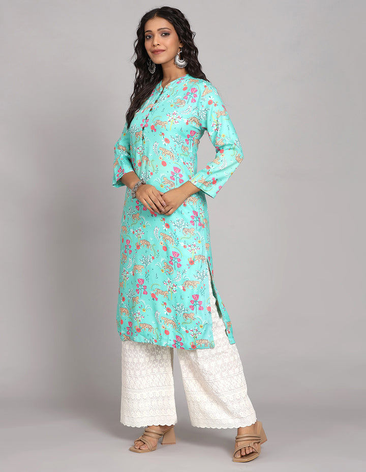 Side profile of a woman wearing Aqua Green printed long kurti  with three-quarter sleeve paired with white wide leg palaazo , showcasing the kurti's length and the smooth drape over the body