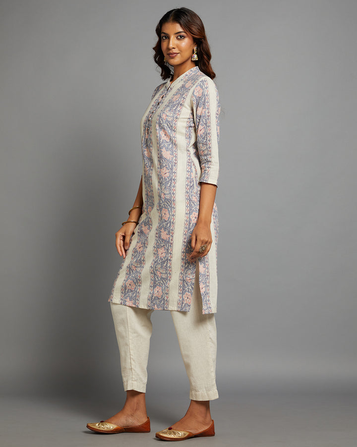 Side profile of a woman wearing a off white kurti with collar neck and wooden button design with three-quarter sleeve paired with white pant , showcasing the kurti's length and the smooth drape over the body