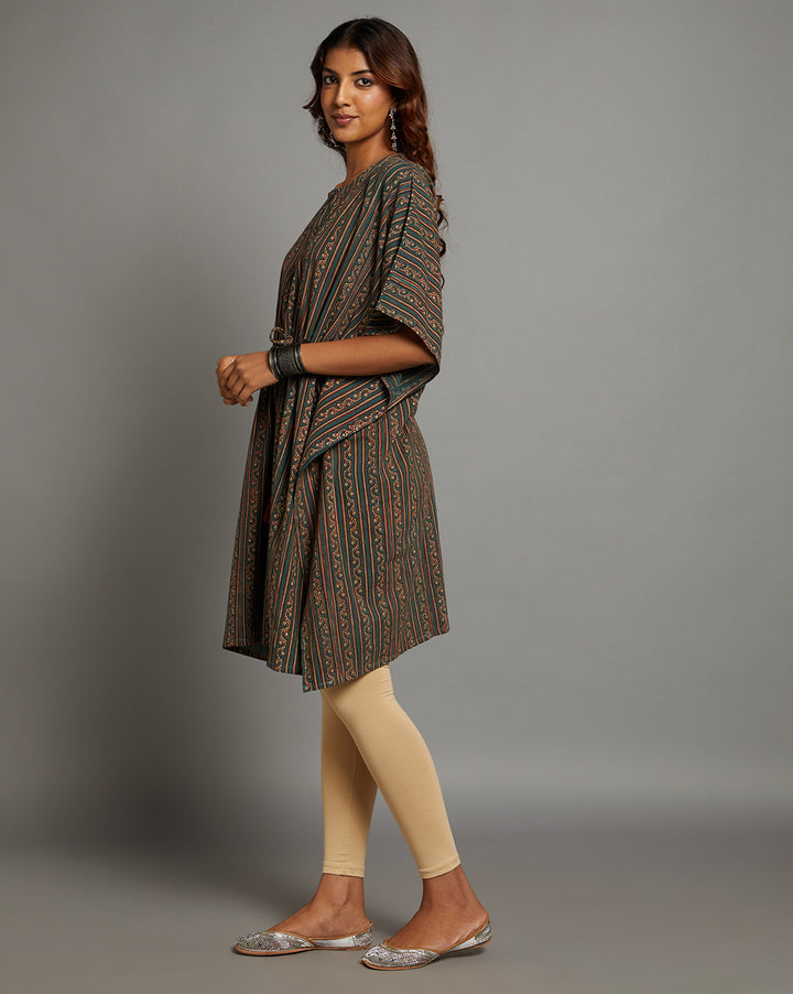 Side profile of a woman wearing a dabu printed bottle green cotton kaftan, paired with skin color legging and half sleeve, showcasing the kurti's length and the smooth drape over the body