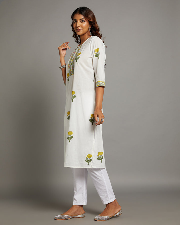 
Side profile of a woman wearing White Cotton Straight Kurta with Chinese Collar and V-Neck with three-quarter sleeve paired with white pant and jutti, showcasing the kurti's length and the smooth drape over the body