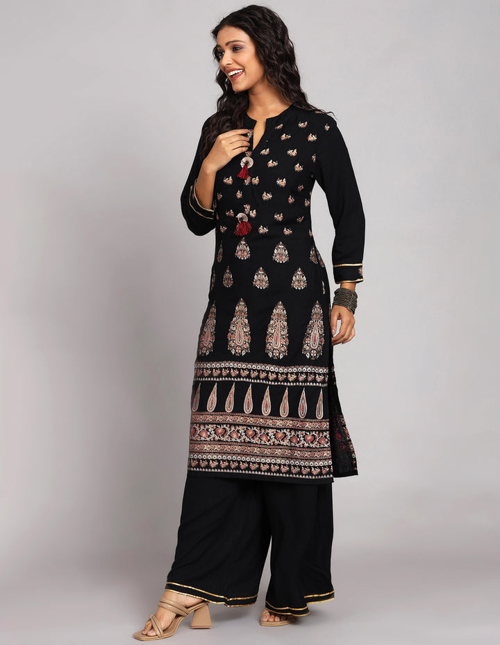 Side profile of a Black Palazzo Set With Hand Block Print with full sleeves paired with black sandals, showcasing the kurti's length and the smooth drape over the body