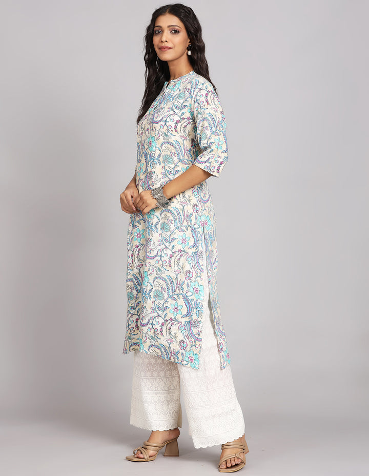 Side profile of a woman wearing a cream long kurti with three-quarter sleeves and white wide leg palazzo, showcasing the kurti's length and the smooth drape over the body