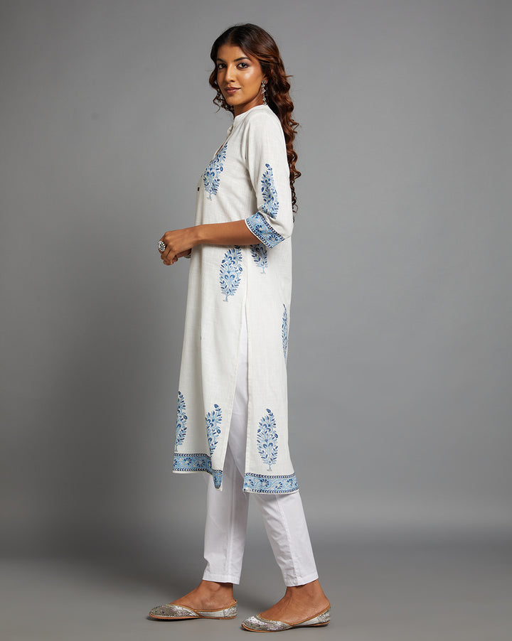 Side profile of a woman wearing White linen Straight Kurta with Chinese Collar and V-Neck with three-quarter sleeve paired with white pant and jutti, showcasing the kurti's length and the smooth drape over the body