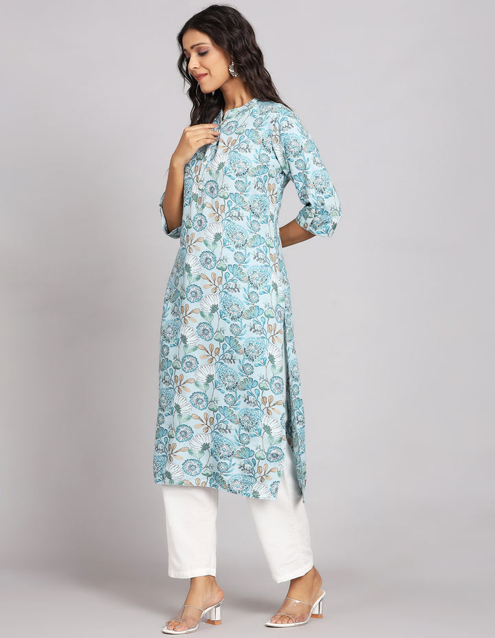 Side profile of a Blue and Grey color Long Kurti with Collar Neck, and three fourth sleeves with white pant and transparent sandals, showcasing the kurti's length and the smooth drape over the body