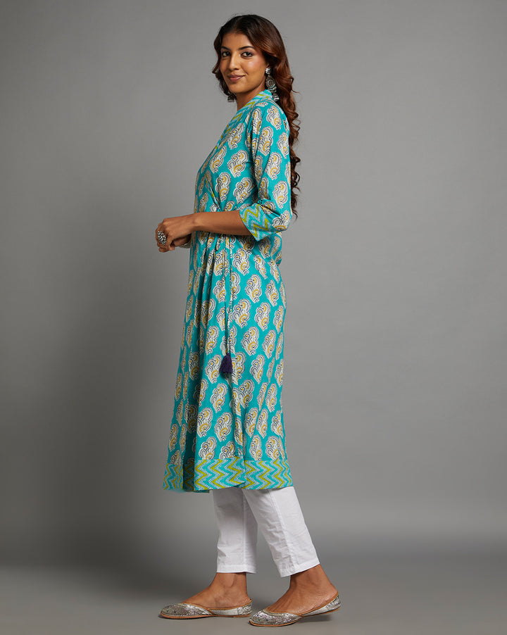 Side profile of a woman wearing Blue Cotton AngrakhaKurta with V-Neck with three-quarter sleeve paired with white pant and jutti, showcasing the kurti's length and the smooth drape over the body