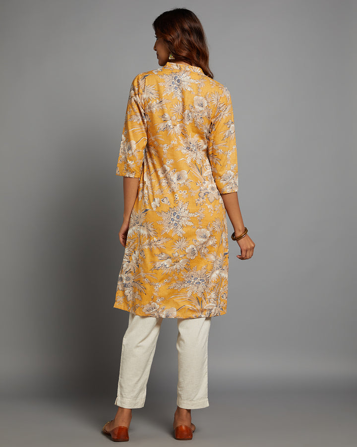 Woman showing the back view of a Yellow Collar Neck Hand Block Cotton Kurti,  with three-quarter sleeve paired with white wide pant and jutti, highlighting the relaxed fit and simple design from behind.
