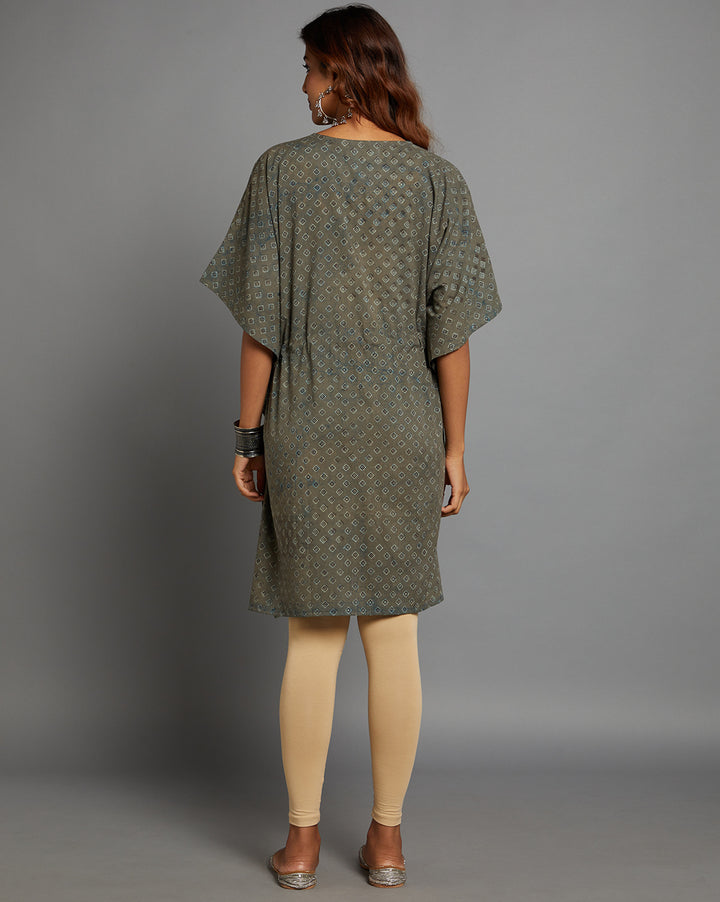 
Woman showing the back view of Grey V-Neck Hand Block Print Cotton Kaftan, paired with skin color legging and half sleeve , highlighting the relaxed fit and simple design from behind.


