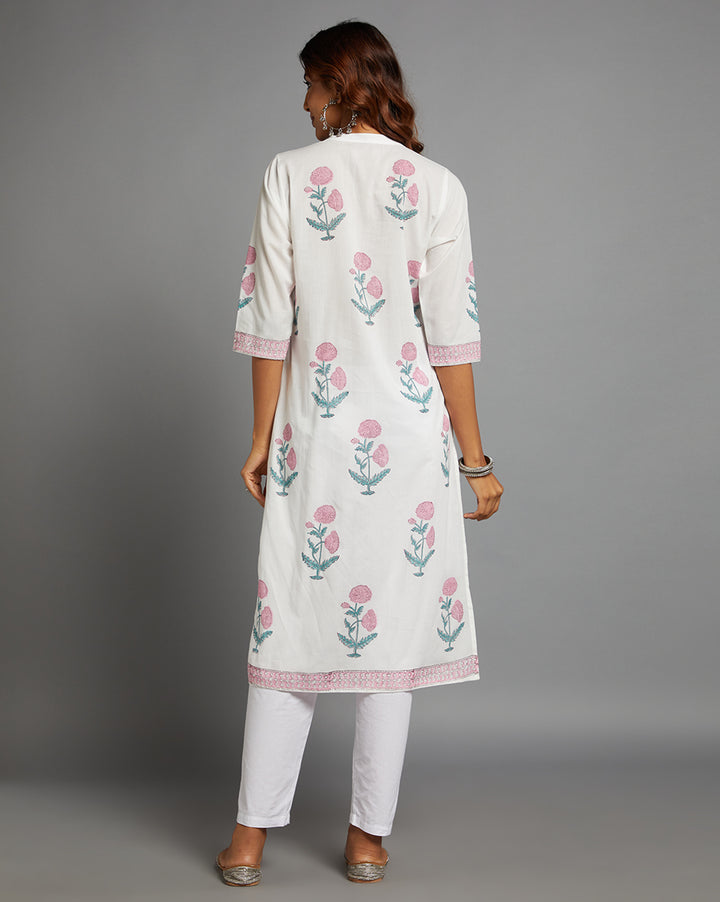 Woman showing the back view of a White V Neck Hand Block Cotton Kurti,  with three-quarter sleeve paired with white pant and jutti, highlighting the relaxed fit and simple design from behind.
