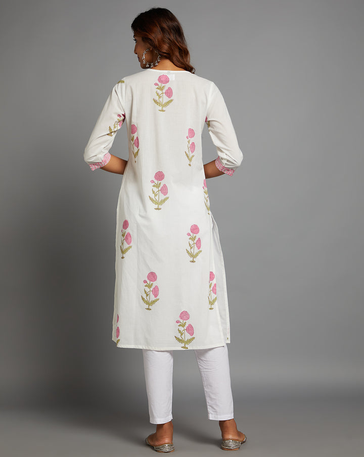 Woman showing the back view of a White Round Neck and Hand Block floral print Cotton Kurti,  with three-quarter sleeve paired with white wide pant and jutti, highlighting the relaxed fit and simple design from behind.
