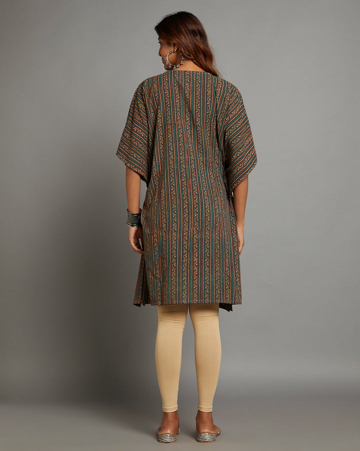 Woman showing the back view of a dabu printed bottle green cotton kaftan, paired with skin color legging and half sleeve , highlighting the relaxed fit and simple design from behind.
