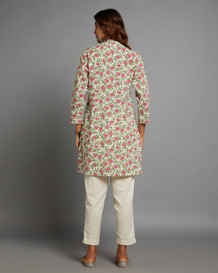 
Woman showing the back view of  Floral Print Cotton A-Line Kurta with Round Neck with three-quarter sleeve paired with off-white pant and jutti, highlighting the relaxed fit and simple design from behind.
