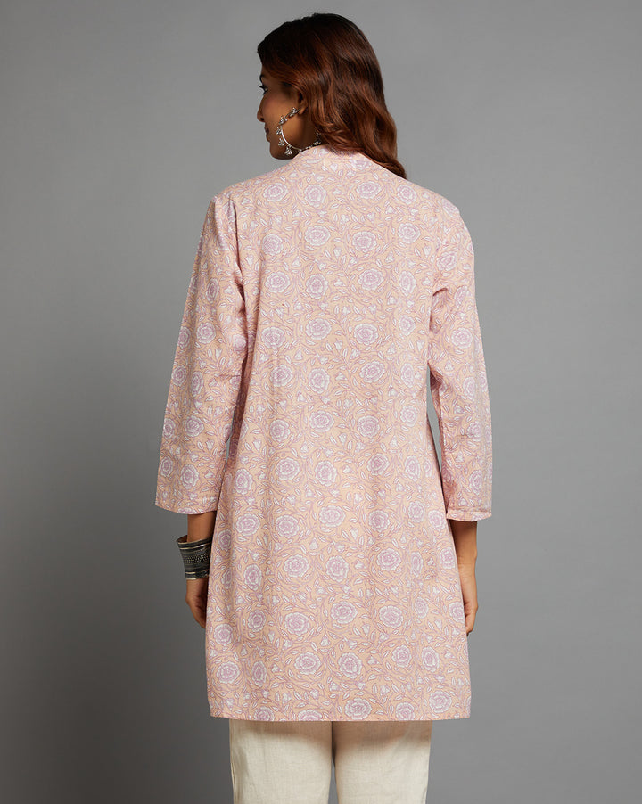 Woman showing the back view of Pink Floral Print Cotton A-Line Kurta with Round Neck with three-quarter sleeve paired with white pant and jutti, highlighting the relaxed fit and simple design from behind.