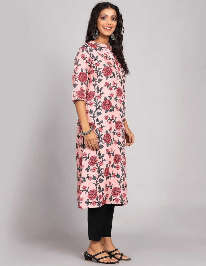 Side profile of a Pink Color Floral Print Long Kurti with collar Neck design and three fourth sleeves with black pant and black sandals, showcasing the kurti's length and the smooth drape over the body