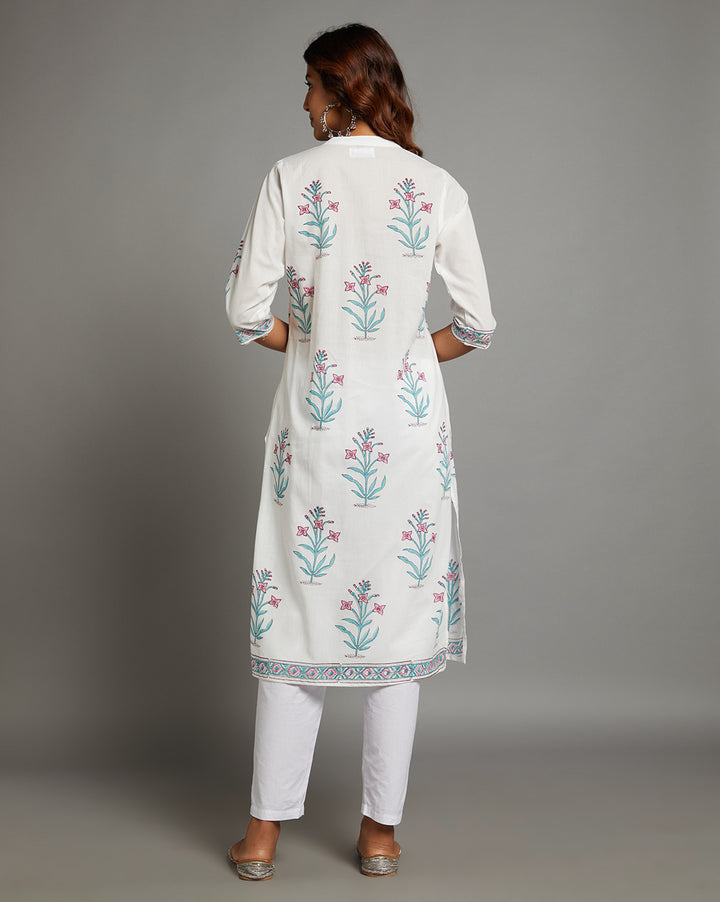 Woman showing the back view of a  white Kurti with Jaipuri floral print with three-fourth sleeves paired with white pant, highlighting the relaxed fit and simple design from behind.