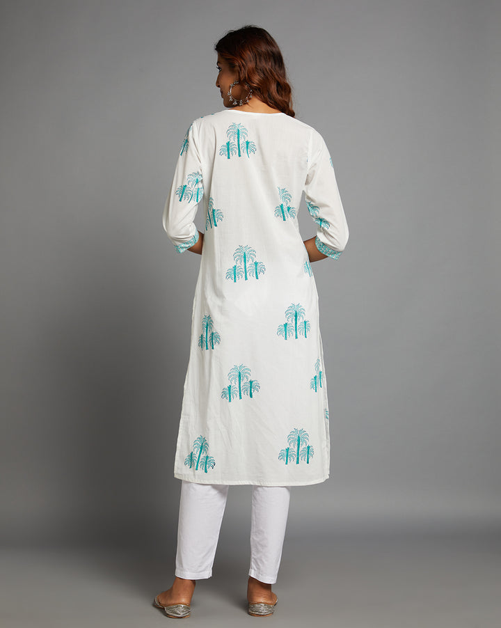 Woman showing the back view of a White Round Neck Hand Block Cotton Kurti,  with three-quarter sleeve paired with white pant and jutti, highlighting the relaxed fit and simple design from behind.
