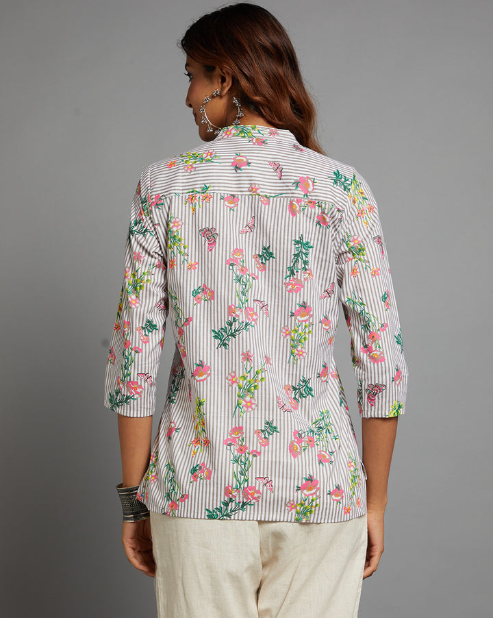 Woman showing the back view of Grey Floral print V neck Short Kurta  with V-Neck with three-quarter sleeve paired with off-white pant and jutti, highlighting the relaxed fit and simple design from behind.