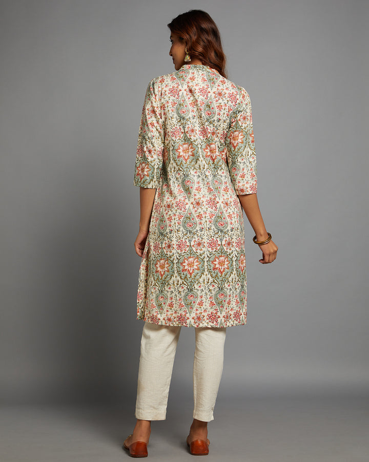 Woman showing the back view of a Yellow color floral print kurti, with three-quarter sleeve paired with white pant and jutti, highlighting the relaxed fit and simple design from behind.
