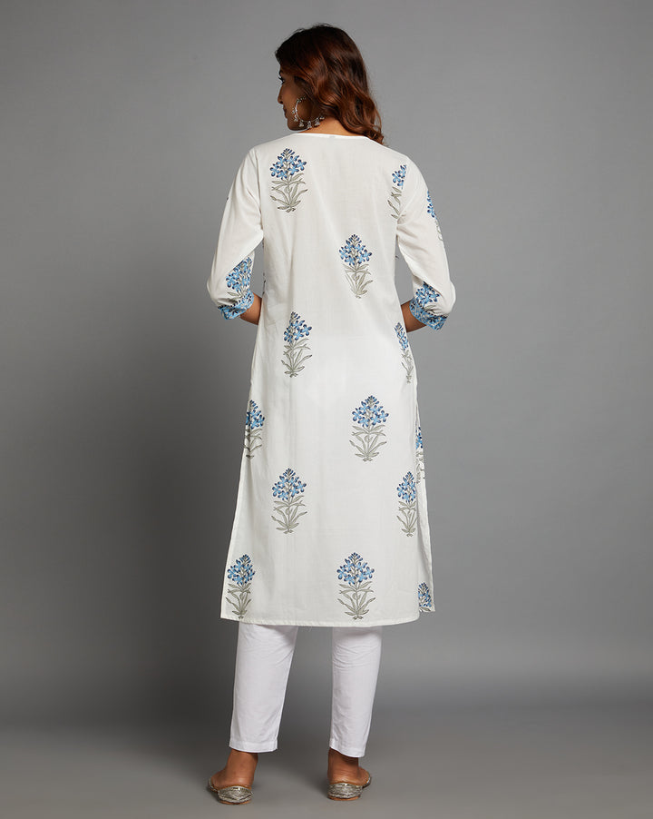 Woman showing the back view of a White Round Neck Hand Block Cotton Kurti,  with three-quarter sleeve paired with white pant and jutti, highlighting the relaxed fit and simple design from behind.
