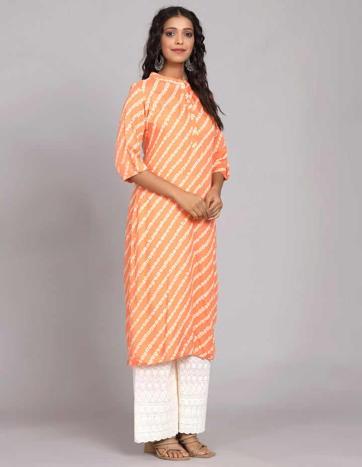 Side profile of a woman wearinga orange color printed long kurti  with three-quarter sleeve paired with white wide leg palaazo , showcasing the kurti's length and the smooth drape over the body