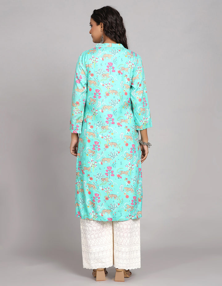 Woman showing the back view of a Aqua Green color printed long kurti with three-quarter sleeve paired with white wide leg palaazo and brown sandals, highlighting the relaxed fit and simple design from behind.