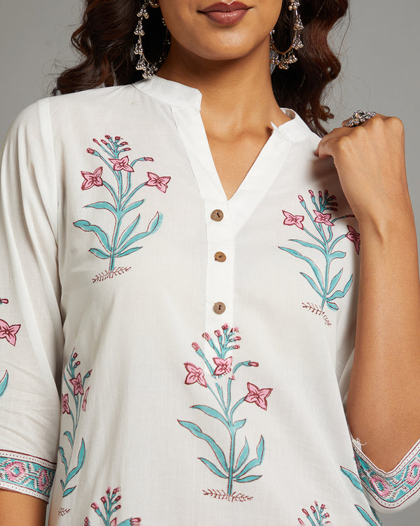 Close-up view of white Kurti with Jaipuri floral print, focusing on the fabric texture, neckline and stitching details.