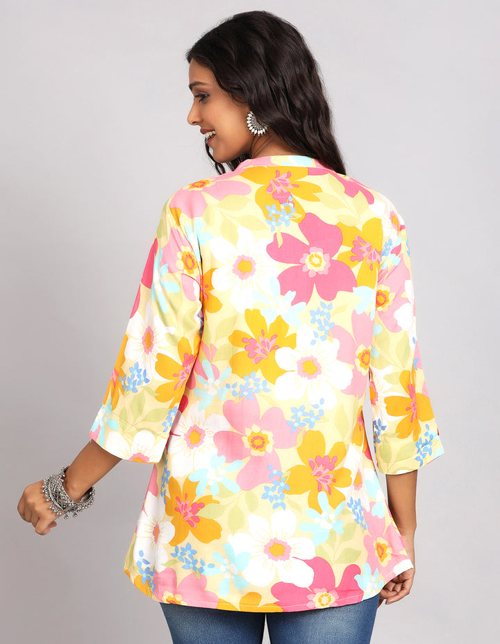 Woman showing the back view of a Multicolor Short Kurti with Collar Neck Line with three-quarter sleeve paired with Blue skinny jeans and brown sandals, highlighting the relaxed fit and simple design from behind.
