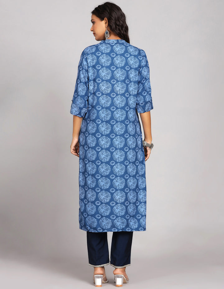 Woman showing the back view of a Blue Long Kurti with Collar Neck Line with three-quarter sleeve paired with navy blue pant and white transparent sandals, highlighting the relaxed fit and simple design from behind.
