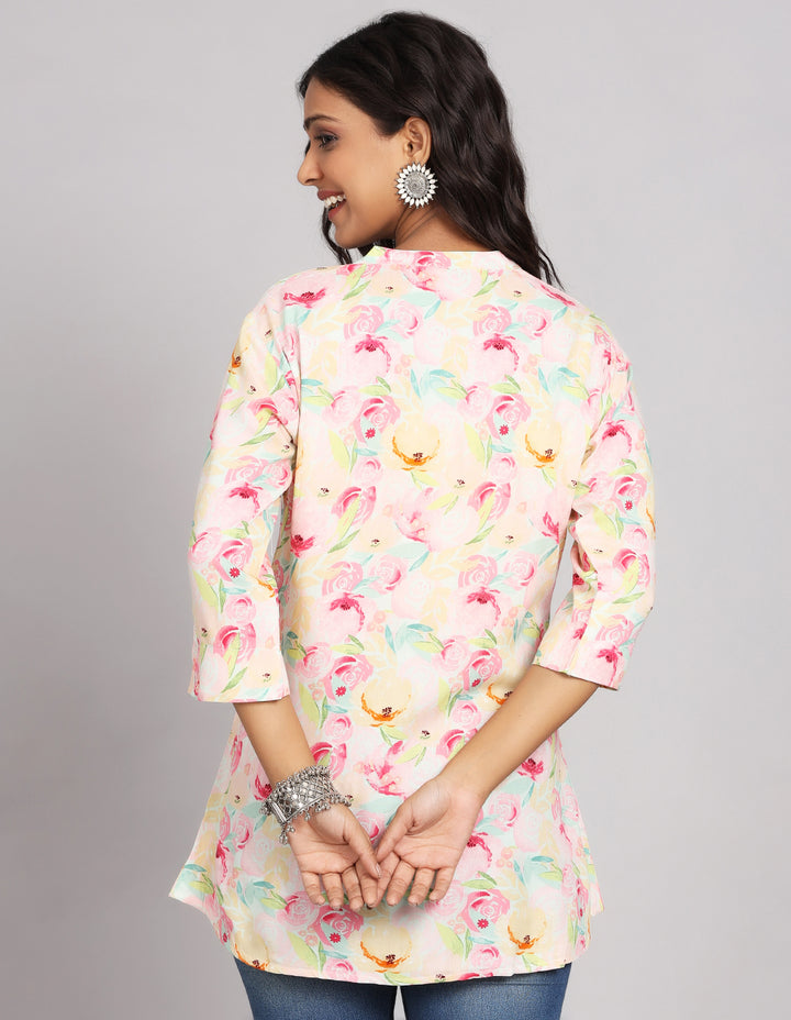 Woman showing the back view of multicolor Pastel Printed Short Kurti with Collar Neck Line and three-quarter sleeve paired with blue skinny jeans and brown sandals, highlighting the relaxed fit and simple design from behind.