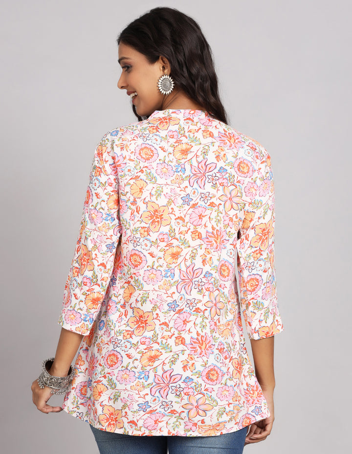 Woman showing the back view of Floral Cream color Short Kurti with Collar Neck line and three-quarter sleeve paired with blue skinny jeans and brown sandals, highlighting the relaxed fit and simple design from behind.