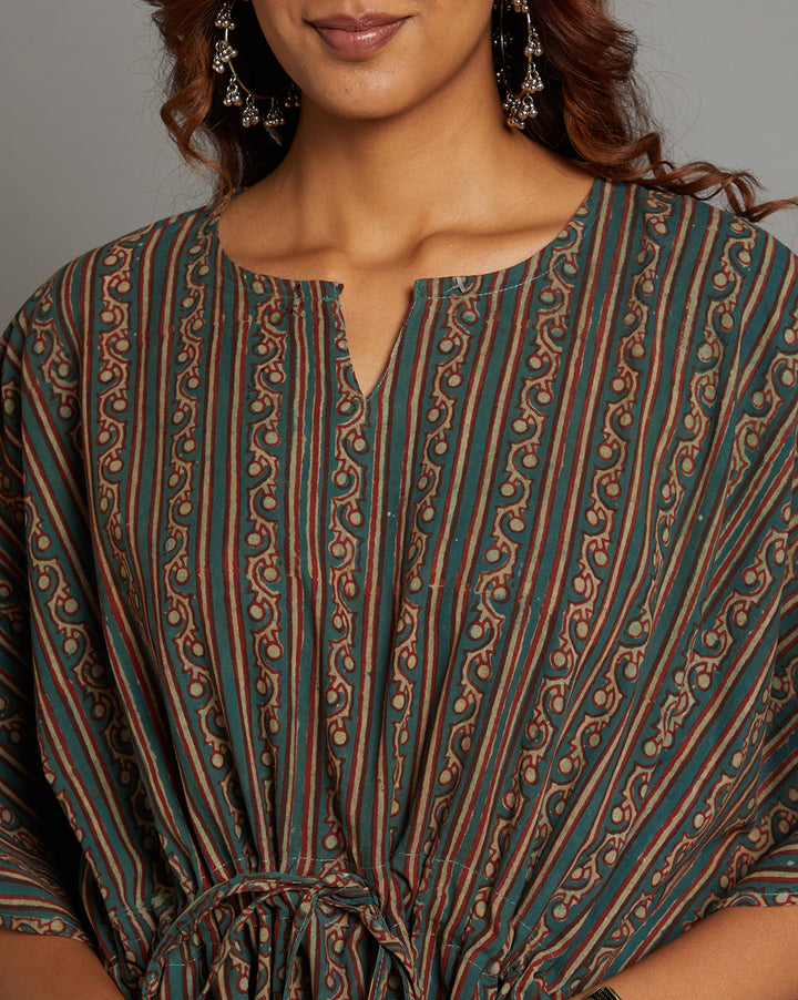 Close-up view of dabu printed bottle green cotton kaftan, focusing on the fabric texture, neckline and stitching details.
