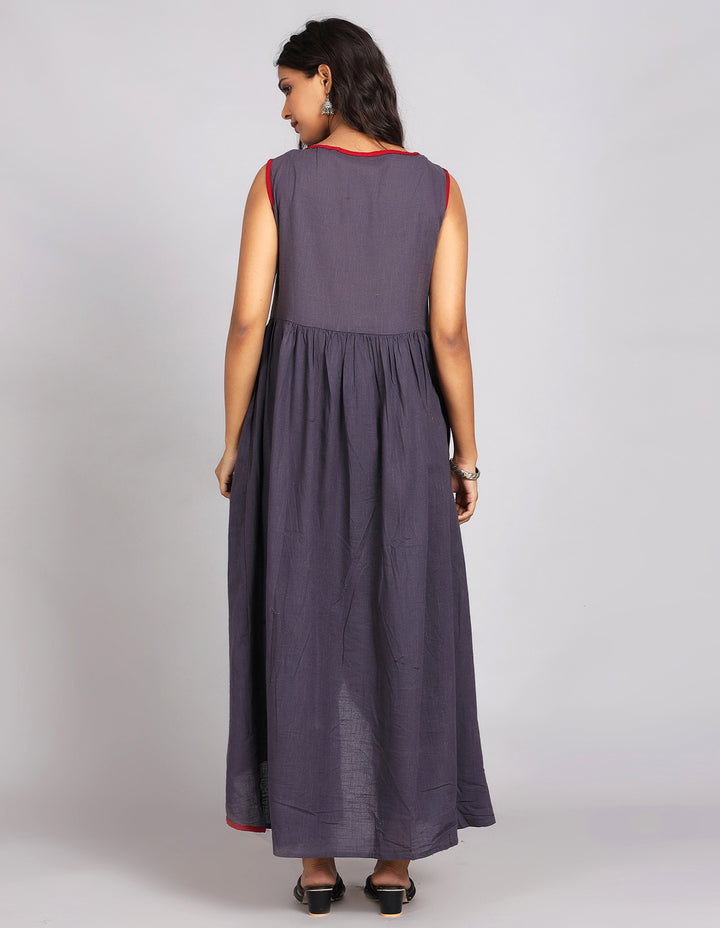 Woman showing the back view of a solid lack charcoal color long kurti with three-quarter sleeve paired with black pant and black sandals, highlighting the relaxed fit and simple design from behind.