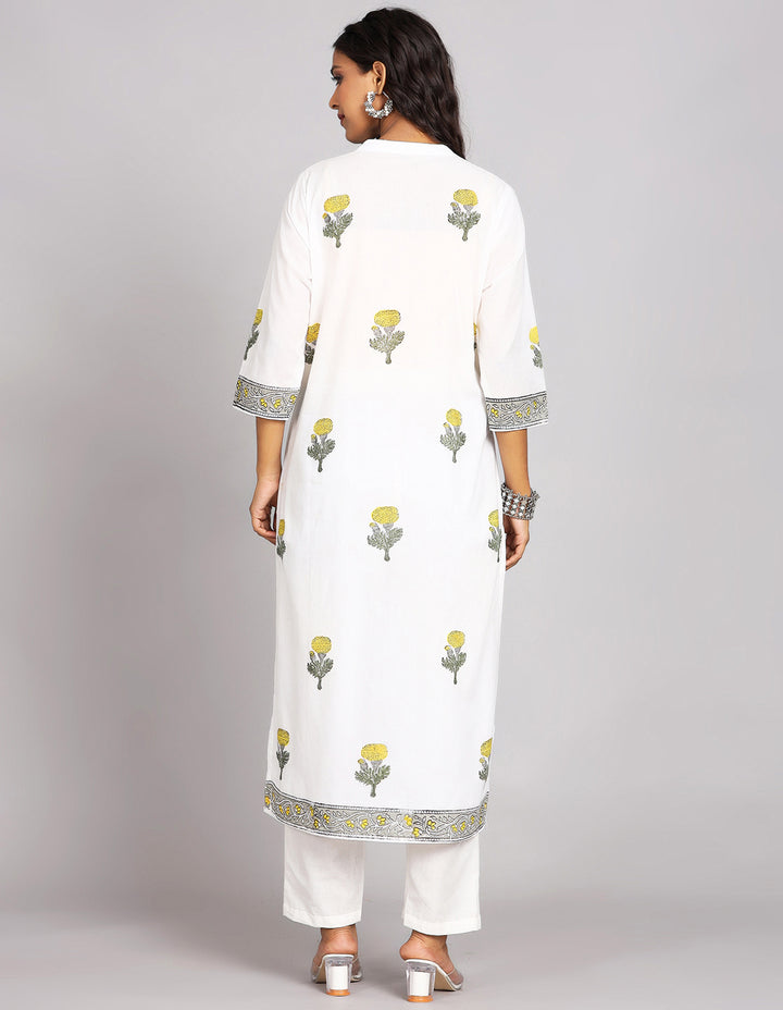 Woman showing the back view of White Long Kurti With Floral print and Collar neck Design and three-quarter sleeve paired with white payjama and white transparent sandals, highlighting the relaxed fit and simple design from behind.