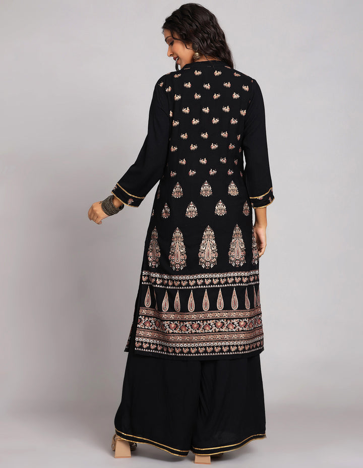 Woman showing the back view of a  Black Palazzo Set With Hand Block Print and  full sleeve, paired with and brown heels, highlighting the relaxed fit and simple design from behind.