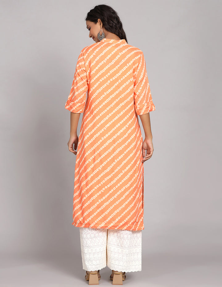 Woman showing the back view of a orange color printed long kurti with three-quarter sleeve paired with white wide leg palaazo and brown sandals, highlighting the relaxed fit and simple design from behind.